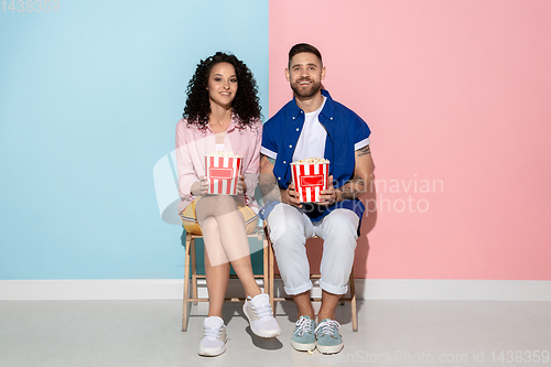 Image of Young emotional man and woman on pink and blue background