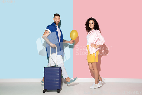 Image of Young emotional man and woman on pink and blue background