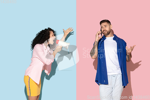 Image of Young emotional man and woman on pink and blue background