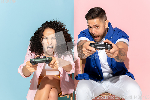 Image of Young emotional man and woman on pink and blue background