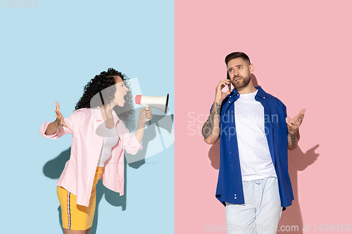 Image of Young emotional man and woman on pink and blue background