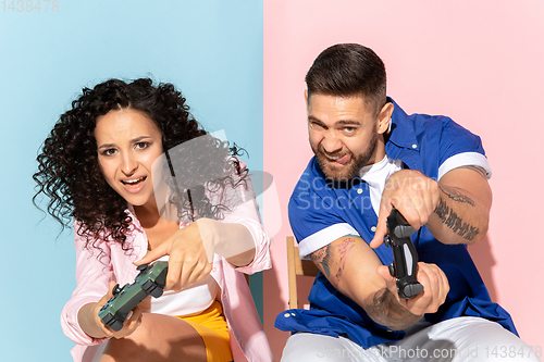 Image of Young emotional man and woman on pink and blue background