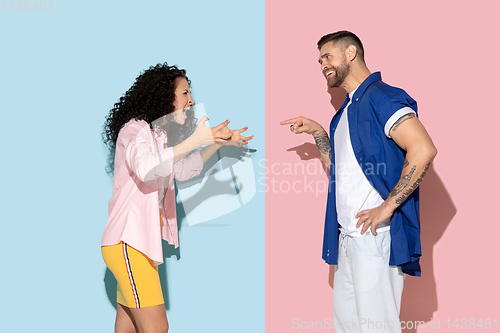 Image of Young emotional man and woman on pink and blue background