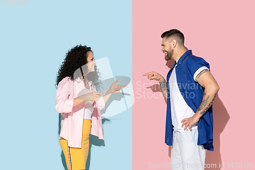Image of Young emotional man and woman on pink and blue background