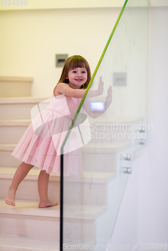 Image of little girl playing on stairs at home