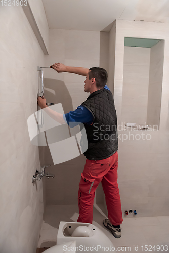 Image of professional plumber working in a bathroom