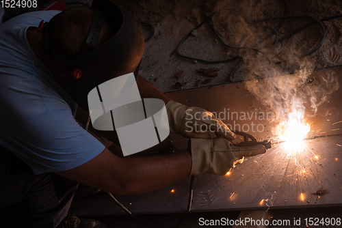 Image of welder with protective mask welding steel