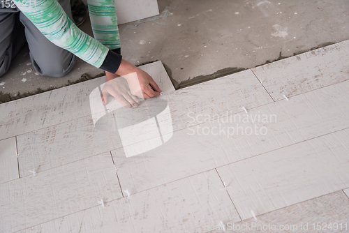 Image of worker installing the ceramic wood effect tiles on the floor