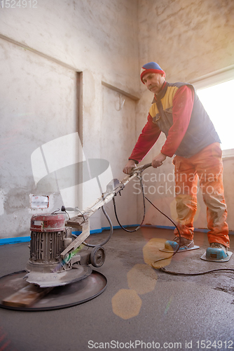Image of worker performing and polishing sand and cement screed floor