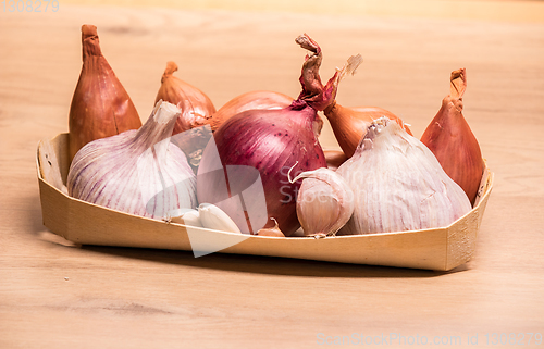 Image of garlic onion shallots in a small wooden basket
