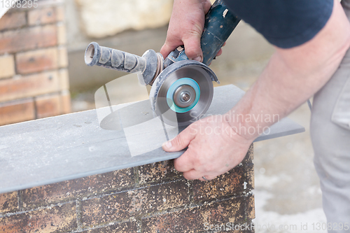 Image of tiler cutting a tile with a grinder