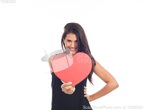 Image of beautiful happy young woman who is holding a big red heart for v