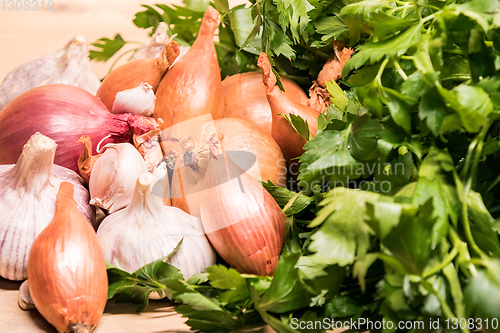 Image of garlic onion shallot parsley on a wooden board