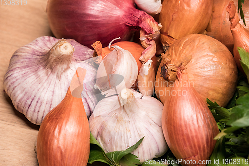 Image of garlic onion shallot parsley on a wooden board