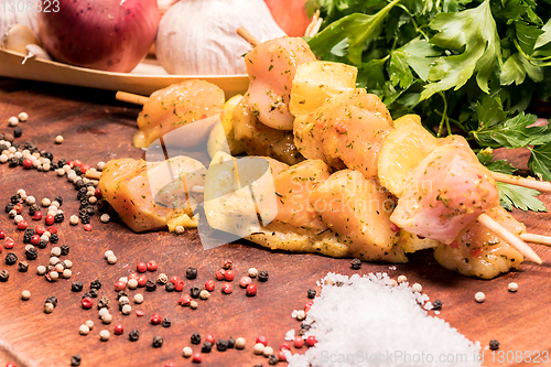 Image of raw chicken skewers marinated with lemon on a wooden board