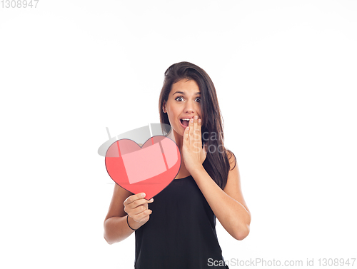 Image of beautiful happy young woman who is holding a big red heart for v