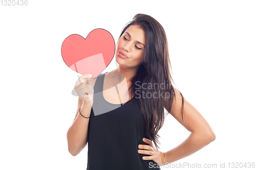 Image of beautiful happy brunette woman holding and showing a big red hea