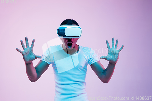 Image of Young african-american man\'s using VR-glasses in neon light