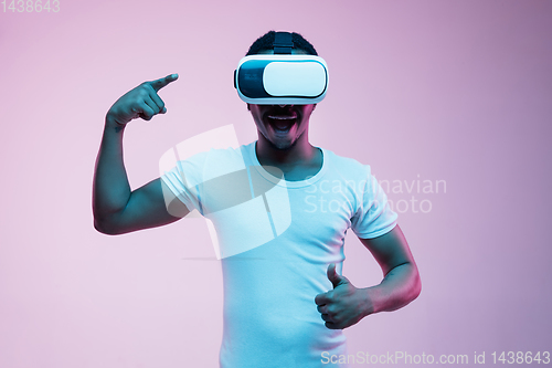 Image of Young african-american man\'s using VR-glasses in neon light
