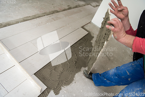 Image of worker installing the ceramic wood effect tiles on the floor