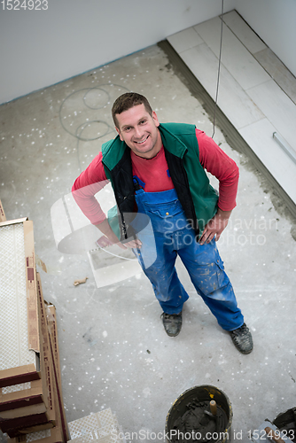 Image of worker installing the ceramic wood effect tiles on the floor