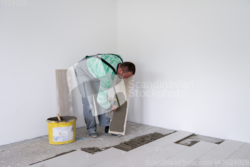 Image of worker installing the ceramic wood effect tiles on the floor