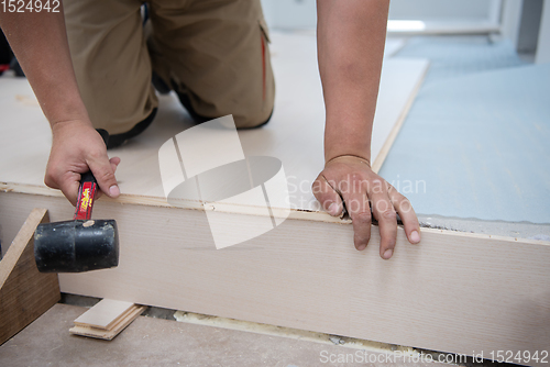 Image of Professional Worker Installing New Laminated Wooden Floor