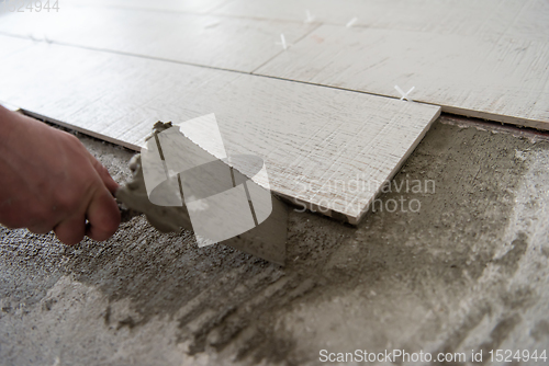 Image of worker installing the ceramic wood effect tiles on the floor