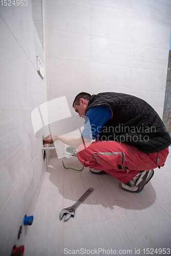 Image of professional plumber working in a bathroom