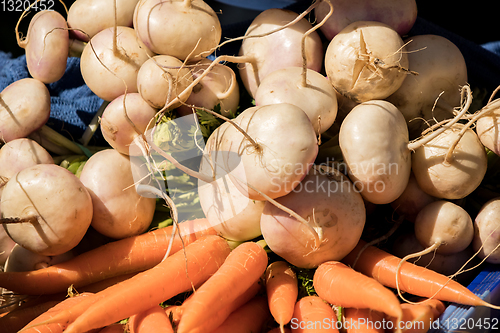 Image of bunches of carrots and fresh turnips on a market stall