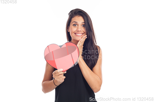 Image of beautiful happy brunette woman holding and showing a big red hea