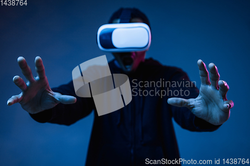 Image of Young african-american man\'s using VR-glasses in neon light