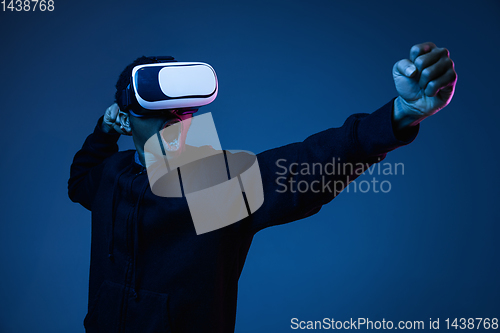 Image of Young african-american man\'s using VR-glasses in neon light