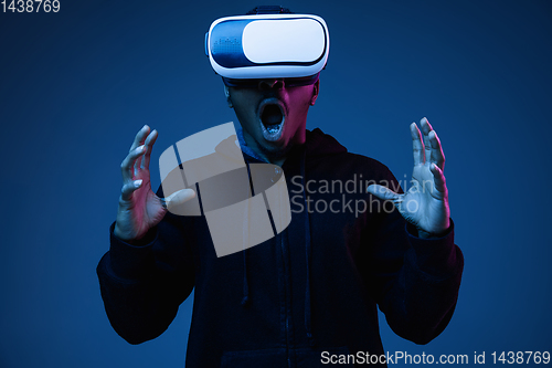 Image of Young african-american man\'s using VR-glasses in neon light