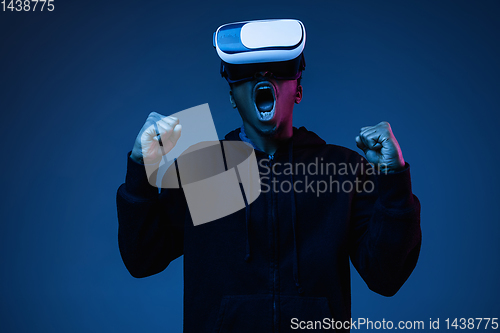 Image of Young african-american man\'s using VR-glasses in neon light