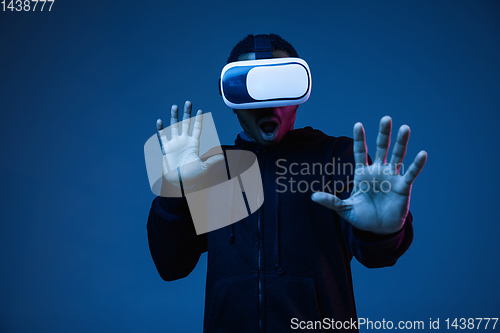 Image of Young african-american man\'s using VR-glasses in neon light