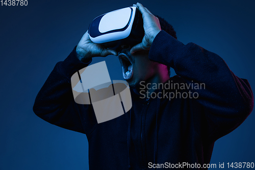 Image of Young african-american man\'s using VR-glasses in neon light