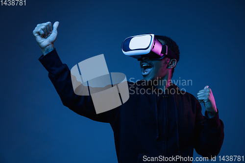 Image of Young african-american man\'s using VR-glasses in neon light