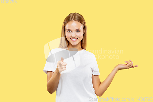 Image of Caucasian young woman\'s half-length portrait on yellow background