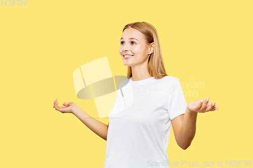 Image of Caucasian young woman\'s half-length portrait on yellow background