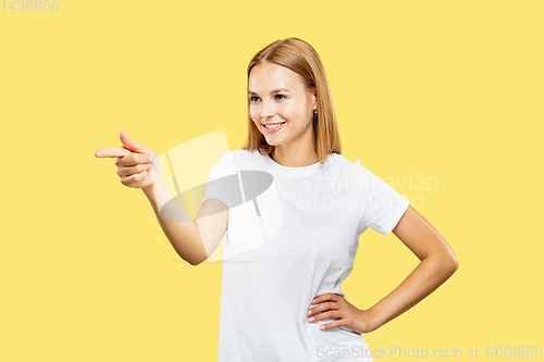 Image of Caucasian young woman\'s half-length portrait on yellow background