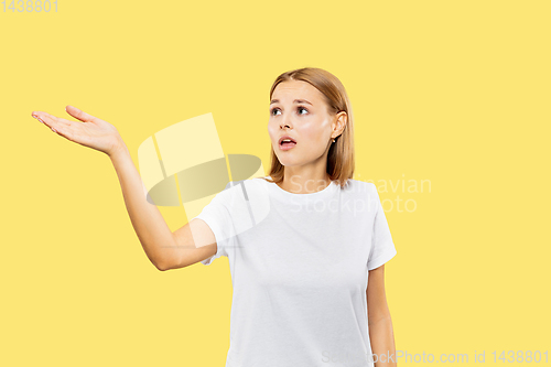 Image of Caucasian young woman\'s half-length portrait on yellow background