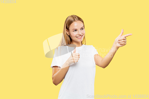 Image of Caucasian young woman\'s half-length portrait on yellow background