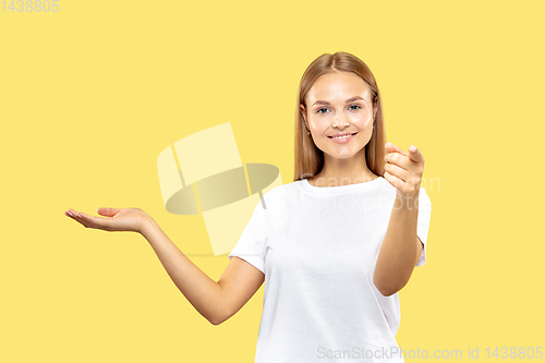 Image of Caucasian young woman\'s half-length portrait on yellow background