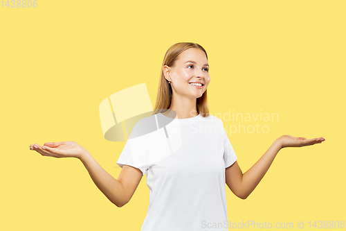 Image of Caucasian young woman\'s half-length portrait on yellow background