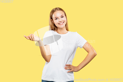Image of Caucasian young woman\'s half-length portrait on yellow background