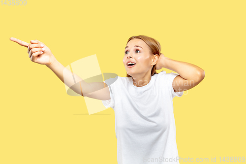 Image of Caucasian young woman\'s half-length portrait on yellow background