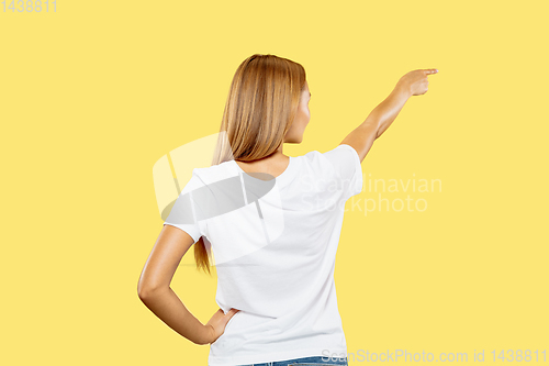 Image of Caucasian young woman\'s half-length portrait on yellow background
