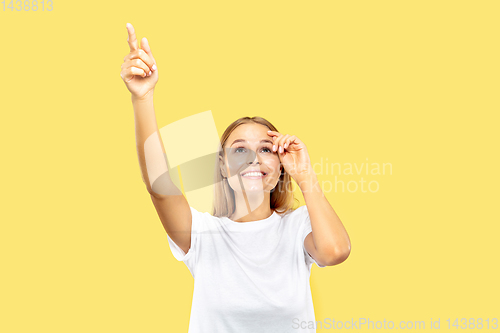 Image of Caucasian young woman\'s half-length portrait on yellow background