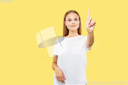 Image of Caucasian young woman\'s half-length portrait on yellow background